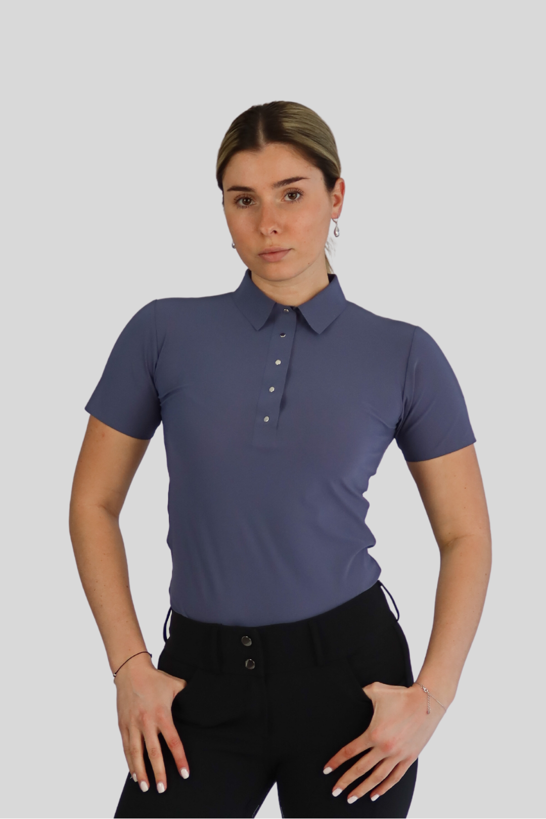 Woman wearing a blue polo shirt and black leggings on a white background